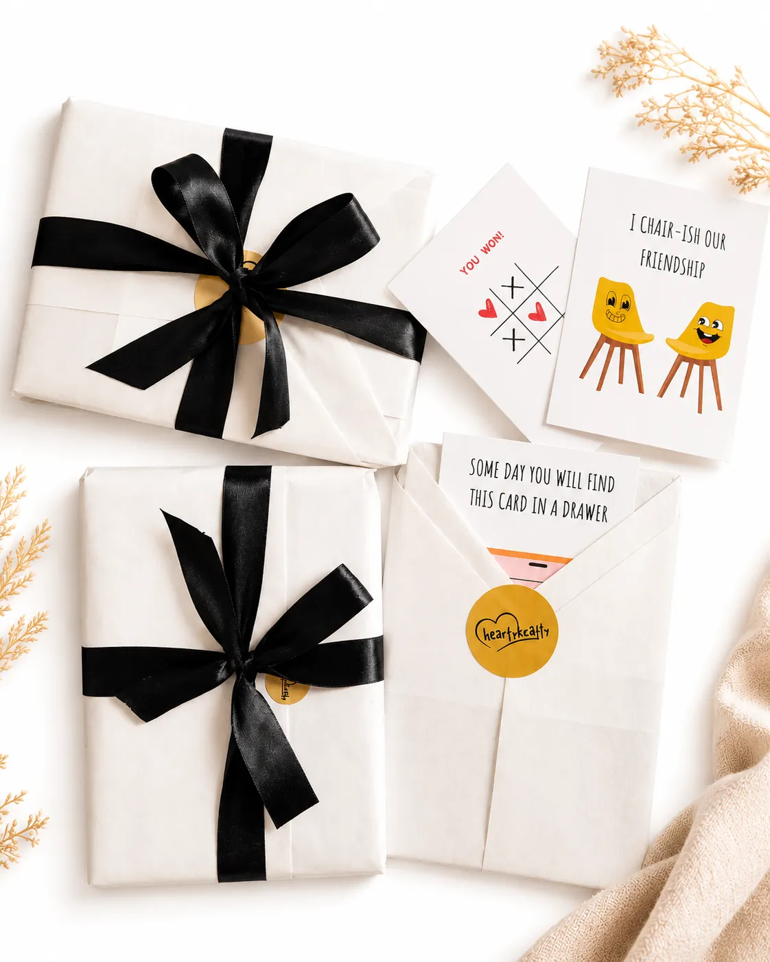 Wrapped gift boxes tied with black ribbon, with printed cards laid alongside